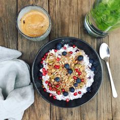 a cake with berries, blueberries and nuts on it next to a glass of orange juice