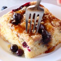 a fork is stuck into a piece of blueberry crumb cake on a plate