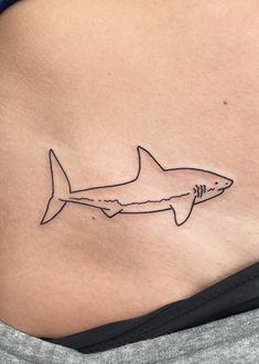 a woman's stomach with a tattoo of a shark