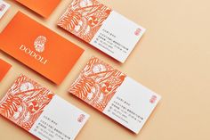 orange and white business cards sitting on top of an orange surface with the word jodo written in chinese