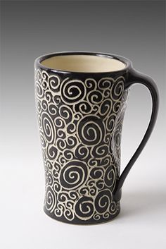 a black and white coffee mug with swirls on it