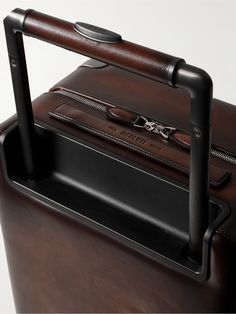 Berluti's 'Scritto' motif was originally hand-calligraphed on its leather goods. This 'Formula 1005' suitcase has been made in Italy from signature Venezia Softy leather and embossed with the iconic lettering. Equipped with an internal zipped compartment and pocket on the front, it's the ideal size for carry-on luggage. Luxury Cognac Briefcase With Luggage Sleeve, Designer Leather Rectangular Luggage, Designer Leather Luggage For Business Trips, Designer Leather Luggage With Sleeve, Designer Rectangular Leather Luggage, Designer Brown Luggage For Business, Designer Brown Business Luggage, Luxury Leather Case In Cognac, Luxury Leather Case In Cognac Color