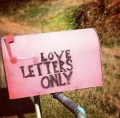 a pink mailbox with the words love letters only written on it in black ink