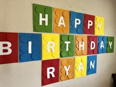 birthday decorations made out of lego blocks are displayed on the wall in front of a white wall