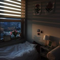 a bedroom with a bed, lamp and pictures on the wall