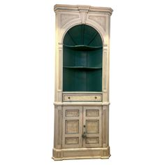 an antique china cabinet with green glass doors