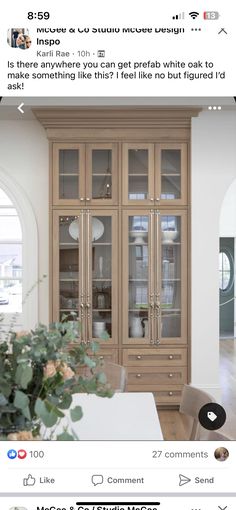 a wooden cabinet with glass doors in a living room next to a table and chairs