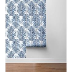 a blue and white wall hanging next to a window with an abstract leaf pattern on it