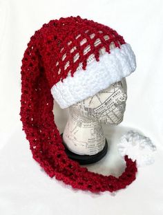 a red and white knitted hat on top of a mannequin head