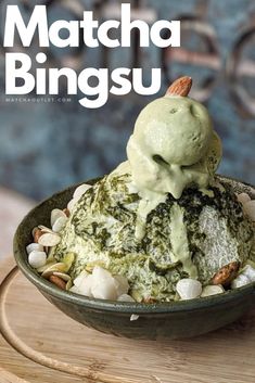 a bowl filled with ice cream and nuts on top of a wooden table next to a sign that says matcha bingsu