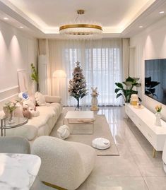 a living room filled with white furniture and a flat screen tv mounted on the wall