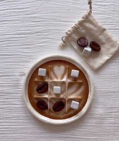 a cup of hot chocolate with marshmallows in it on a white table