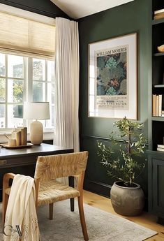 an office with green walls and white drapes on the windowsills, a wooden chair in front of a desk that has a potted plant next to it