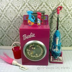 a pink toy machine sitting on top of a counter next to a cup and brush