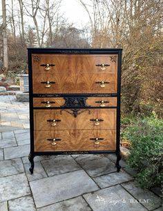 an antique chest of drawers with brass pulls and knobs on the front, sitting in a garden