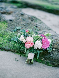 a bouquet of flowers sitting on top of a rock