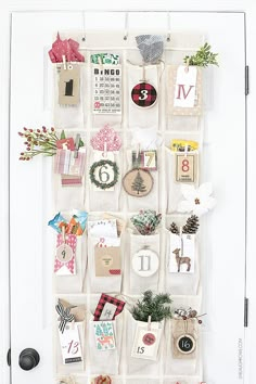 a white door decorated with christmas cards and wreaths, hanging on the side of it