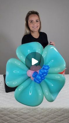 a woman sitting on top of a bed holding an inflatable flower shaped object