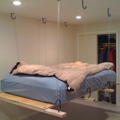 a bed suspended from the ceiling in a room