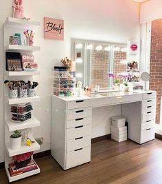 a room with a desk, mirror and shelves filled with makeup products on it's sides