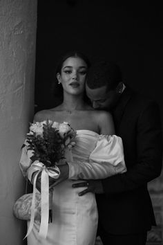 a bride and groom embracing each other in black and white