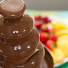 a chocolate fondant stacked on top of each other in front of a plate of fruit