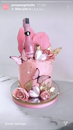 there is a pink cake with flowers on it and a bottle in the top tier