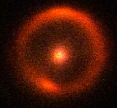 an orange circular object is seen in the dark night sky with no light on it