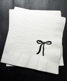 two white napkins with black bows on them