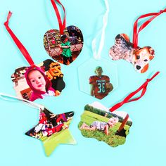 four christmas ornaments with different pictures hanging from red ribbon on blue background, top view