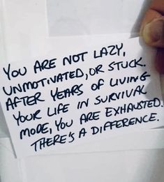 someone is holding a note that says you are not lazy, unmotched or stuck after years of living your life in survived