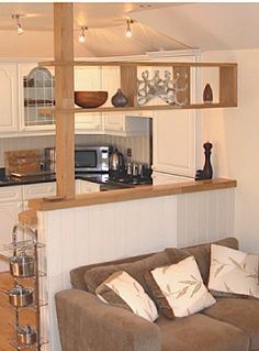 a living room filled with furniture next to a kitchen