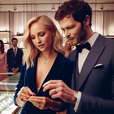 a man and woman looking at rings in a jewelry store with other people behind them