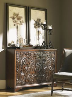 an ornate wooden cabinet with two mirrors above it and a chair in front of it