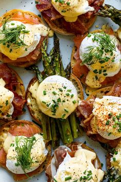 a plate with eggs, asparagus and bacon on top of toasted bread