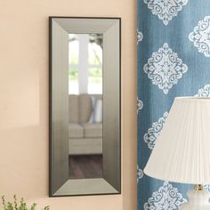 a lamp is next to a mirror on the wall in a room with blue and white walls