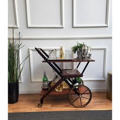 a bar cart with bottles and glasses on it