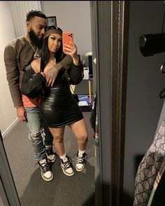 a man and woman taking a selfie in the mirror