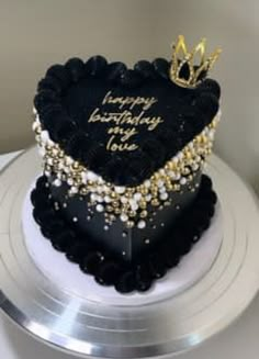 a black and gold heart shaped birthday cake