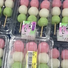 several trays of green and pink cake pops in plastic containers with stickers on them