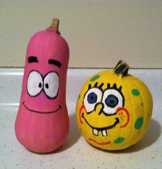 two pumpkins with faces painted on them sitting next to each other