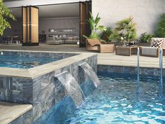 an outdoor swimming pool with waterfall and lounge area