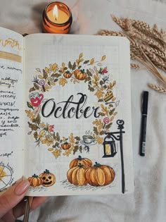 a hand holding an open book with the words october written on it and pumpkins