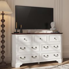 a white dresser with drawers and a flat screen tv mounted on it's side