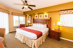 a bed room with a neatly made bed and a ceiling fan