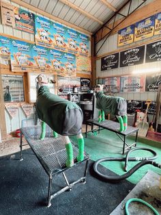 the inside of a building with two horses covered in blankets and hoses attached to them