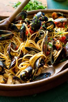 a bowl filled with pasta and mussels on top of a table