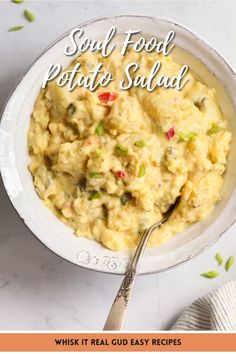 a white bowl filled with potato salad on top of a table next to a fork