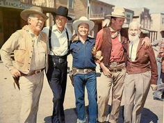 an old photo of four men in cowboy hats posing for the camera with one man wearing a hat