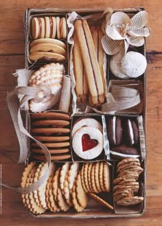 a box filled with lots of different types of cookies and pastries on top of a wooden table